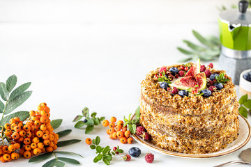 Carrot cake decorated with berries and figs on a white plate. Traditional donkey pastries. Copy space