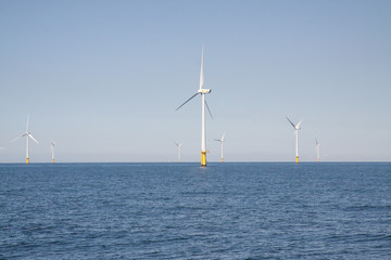 Wind turbines in an offshore wind farm in the North Sea just off the coast of the Netherlands, on a clear day.