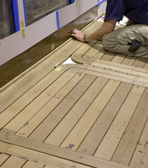 Ship building industry. Super sailing yacht. Assembling the wooden floor of the deck.