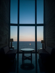 Sunset Meeting Space for Business with incredible views to the Sea while a Sailboat is crossing in front of the High Vertical Windows