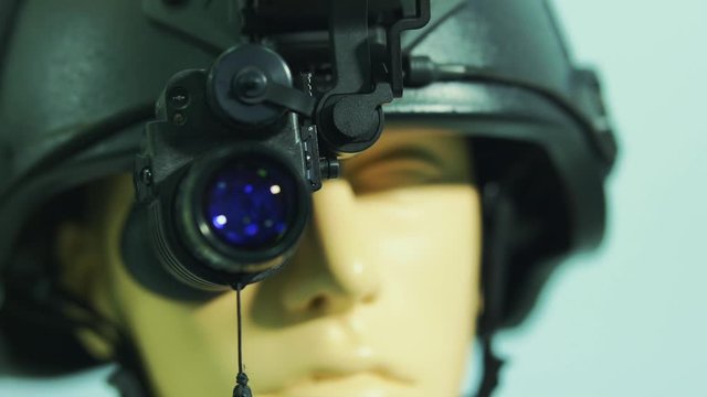 Tactical military all black helmet with scope attached to it.