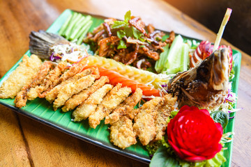sea bass fish fillet cooked food Thai style Asian - Salad seabass fried fish crispy decorated on plate served on wooden table food dinner