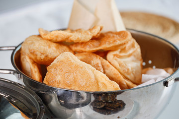 Fresh homemade Puri Indian bread drying in a colander.