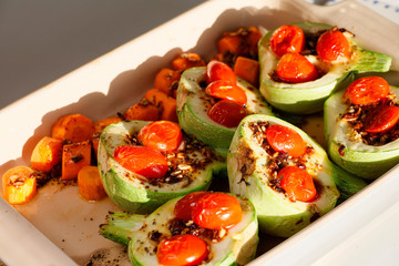 Round zuchini in a pan with carrots, marinade and tomatoes.