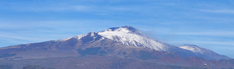 Fototapeta na wymiar Etna volcano covered in snow. View from afar. Sicily