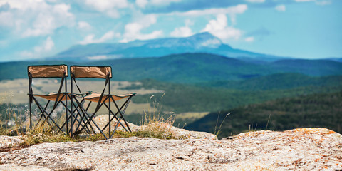 Fototapeta na wymiar Adventure travel. Time to travel and travelling concept. Breathtaking mountains view. Tourist chair on top of mountain