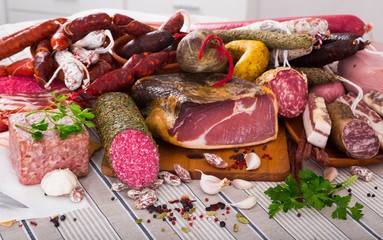 Variety of meats, sausages and mince with herbs on table