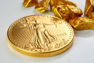 golden american eagle one ounce coin laying on a heap of golden nuggets, golden ore