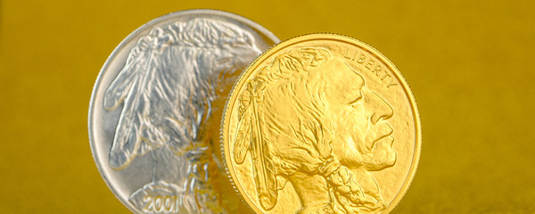 silver and golden american buffalo one ounce coins laying on silver and golden background.