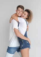 happy couple hugging in jeans clothes on white background. authencit couple having fun indoors.