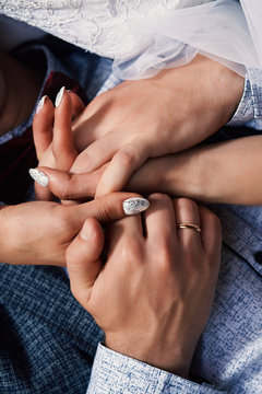 Vertical photo close-up of a young people tenderly holding hands