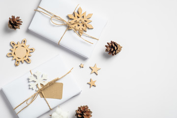 Vintage Christmas gift boxes and wooden decorations on white table. Retro style Christmas background with handmade presents. Winter holidays, Xmas, New Year concept.
