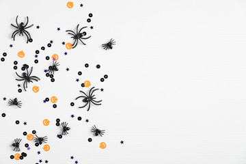 White halloween background with spiders and confetti. Top view with copy space, flat lay. Happy Halloween holiday concept. Halloween sale banner mockup