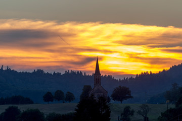 Fototapeta premium Sunset over the village Hofen in the Black Forest with the silhouette of the church