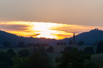 Sunset over the village Hofen in the Black Forest with the silhouette of the church