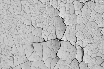 Peeling paint on the wall. Old concrete wall with cracked flaking paint. Weathered rough painted surface with patterns of cracks and peeling. High resolution texture for background and design. Closeup