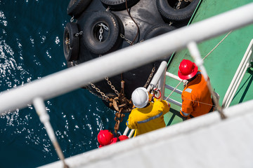 A group of third party, captain and client performing an inspection of boat fender onboard a pipelay barge - obrazy, fototapety, plakaty