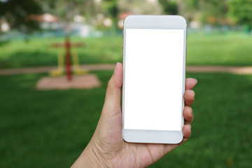 Close up adult hand holding a blank screen smartphone in the park