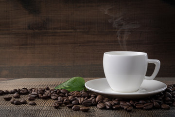 A cup of coffee and coffee beans on the table.