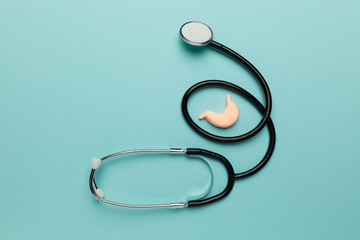 Human stomach on blue background. Treatment of pain and inflammation. Symptom of gastritis and...