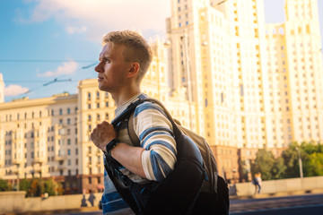 Young blond male tourist with a view of the Stalin high-rise, Soviet architecture