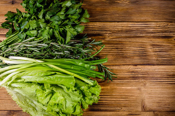 Lettuce rosemary and parsley on a wooden table. Vegan food. Top view
