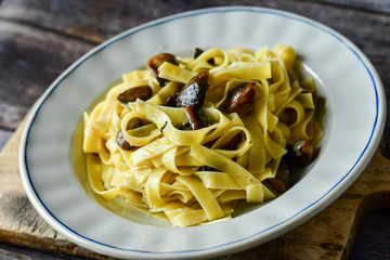 Italian food . Fresh home made  tagliatelle vegetarian  egg pasta  with mushrooms ,parmesan cheese ,fresh parsley  and black pepper.