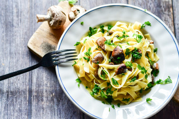 Italian food . Fresh home made  tagliatelle vegetarian  egg pasta  with mushrooms ,parmesan cheese ,fresh parsley  and black pepper.