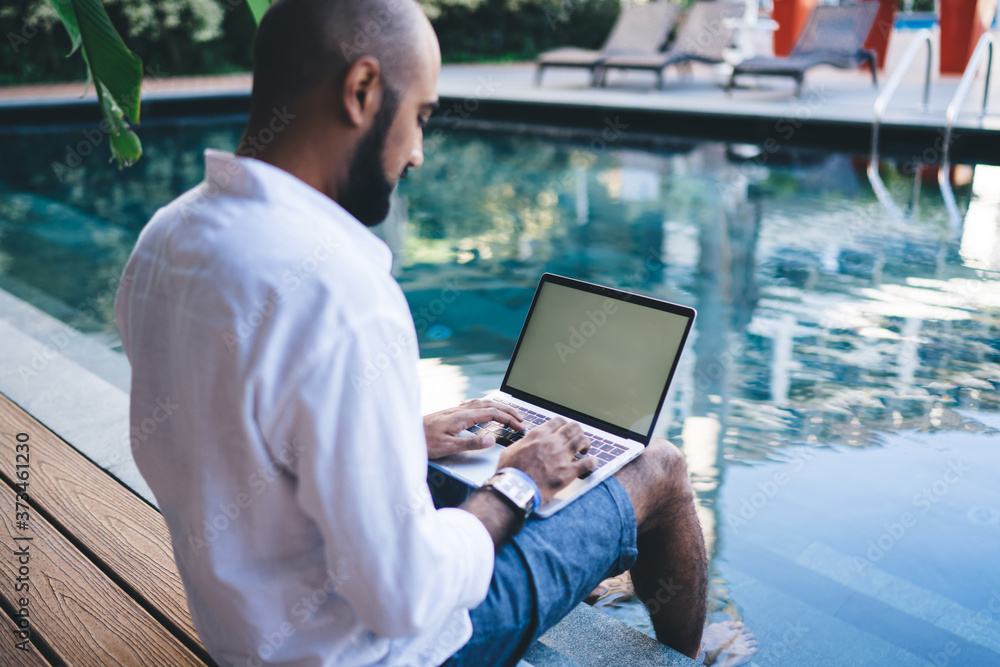Aufkleber skilled digital nomad user sitting at pool terrace in courtyard of own indonesian villa and typing c