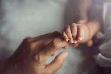 Fotobehang Newborn baby holding mother's hand. © Thanumporn