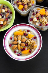 Traditional Turkish Dessert Asure or Noah's Ark Pudding bowls on black surface,vertical image