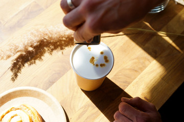Barista prepares coffee in a paper cup