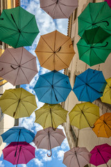 Colorful umbrellas cover a shopping street in Carcassonne, Aude, Occitanie, France