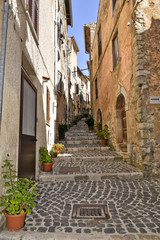 Fototapeta na wymiar A small street between the old houses of Giuliano di Roma, of a medieval village in the Lazio region, Italy.