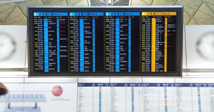 Time lapse. People in international airport looking at the flight information board, checking their flights. Tourists at international airport terminal flight timetable. Travel concept