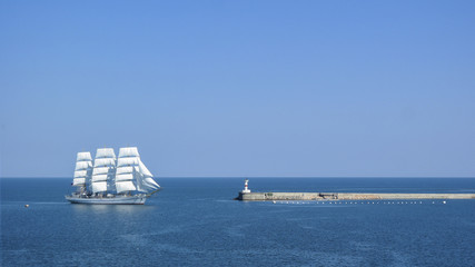 Fototapeta na wymiar the sailboat enters the port, lighthouse, sea