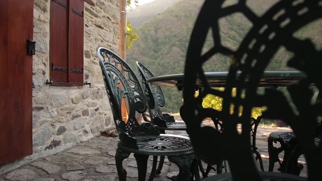 terrasse , mobilier fer forg&eacute; , vue sur la montagne.