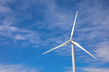 Wind turbine against beautiful blue sky. Alternative energy source