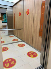 Social distance signs on the floor in the elevator
