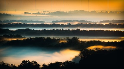 Beautiful morning landscape with fog over the river valley with trees. View from the hill