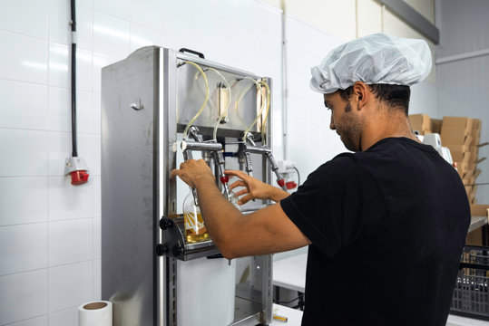 Operator Bottling Manually In The Kombucha Manufacturing Process In A Factory