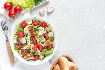 Delicious Fattoush or Arab salad with pita bread, fresh vegetables on plate. Middle Eastern bread salad. Top view