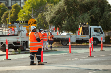 Melbourne, Victoria / Australia - January 2 2020: Traffic control worker is holding stop sign to stop the traffic near Caulfield train station. © Olha