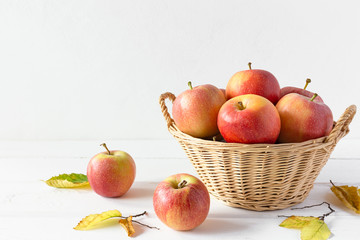 A basket of apples on a white wooden table. Copy space
