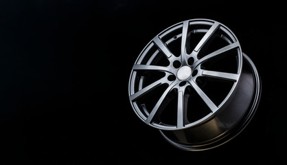 grey Matt caluminum alloy wheel disc on black background. Sports a lot of spokes, copy space