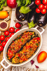 Karniyarik traditional Turkish food from stuffed eggplants with minced meat, tomato, greens and sesame seeds