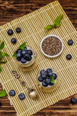 Yogurt with blueberries and chia seeds on wooden cutting board