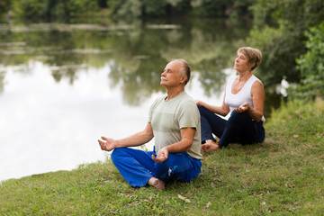 Senior family couple practising meditation outdoors.  yoga. Social Distancing. copy space. Mental Health.
