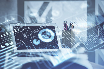 Computer on desktop in office with technology theme hologram. Double exposure. Tech concept.