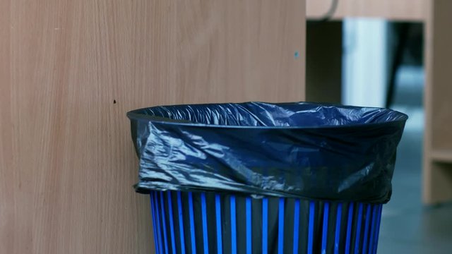 trash bin close-up into which the spoiled office paper falls.